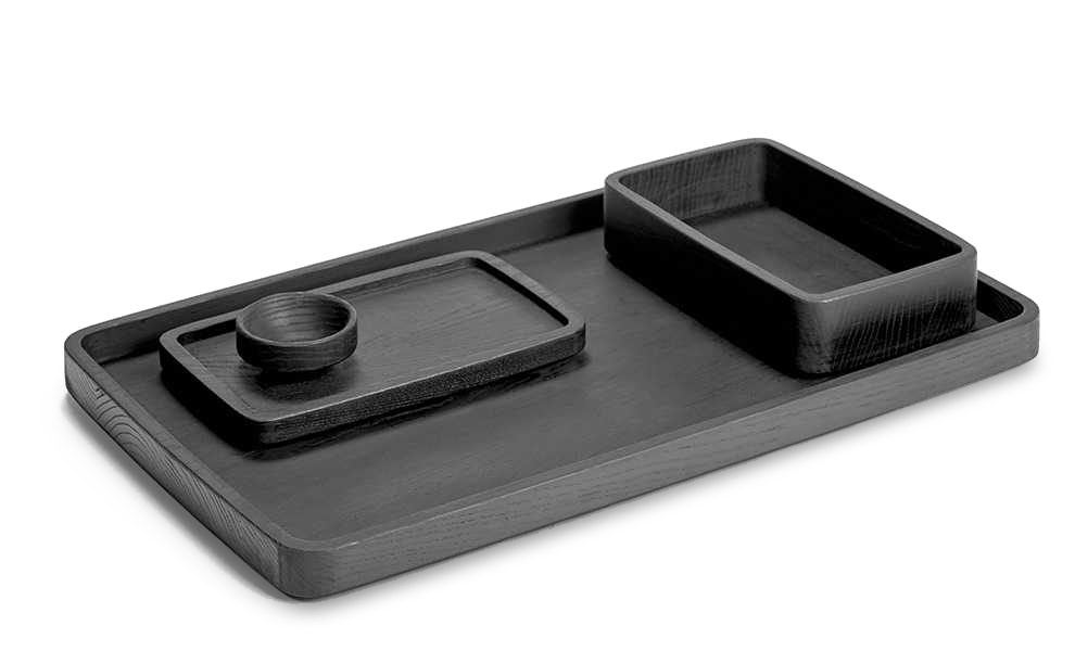 A black tray with two Gestalt Haus trays by Vincent Van Duysen and a cup by SERAX.