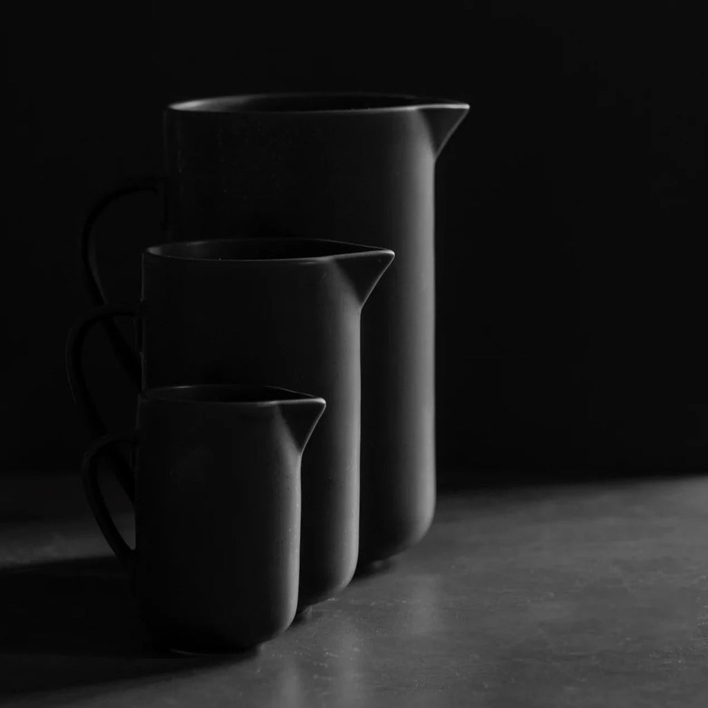 Three LOUISE ROE PISU PITCHERs on a table in front of a dark background at Gestalt Haus.