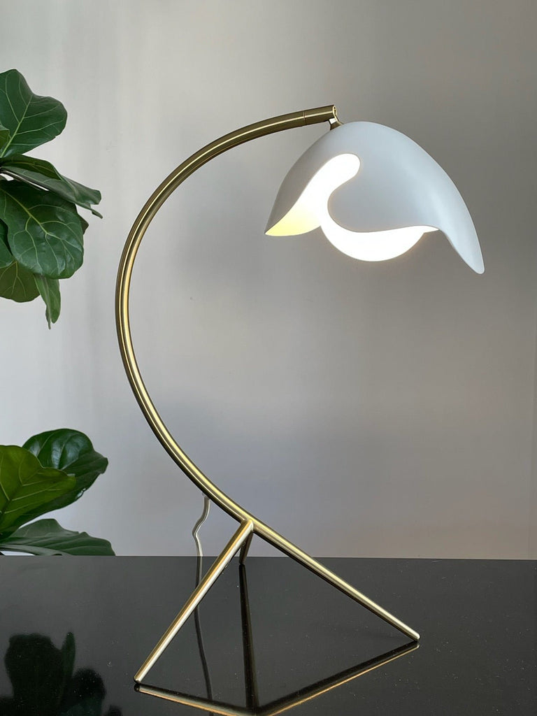 A Gestalt Haus table lamp with a plant on it.