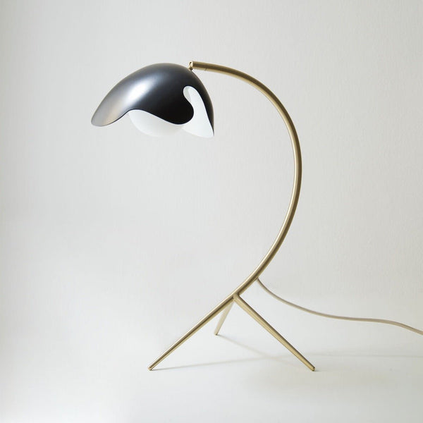 An ATBO PS38 table lamp with a black shade and a gold base, available at Gestalt Haus.