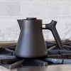 A RAVEN STOVETOP TEA KETTLE from Gestalt Haus sitting on top of a stove.