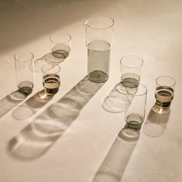 A set of Gestalt Haus RYE GLASSWARE COLLECTION glasses and a AARON PROBYN pitcher on a table.