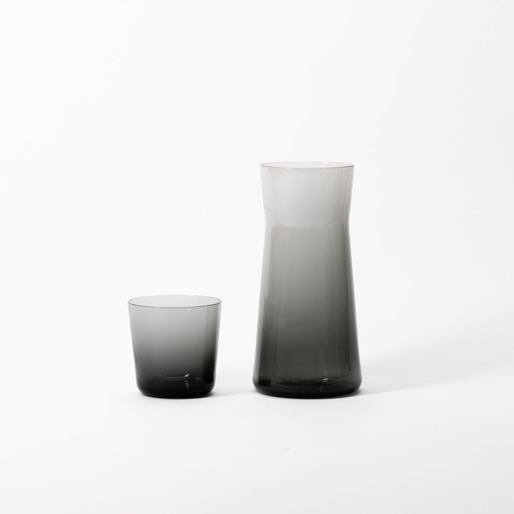 A Short Glass pitcher and cup on a white surface by Gary Bodker Designs.