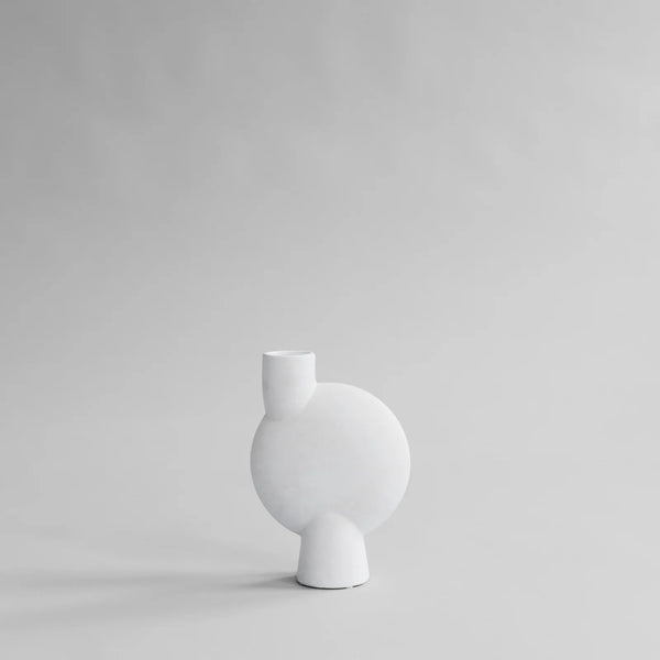 A SPHERE VASE by 101 COPENHAGEN sitting on a grey surface.