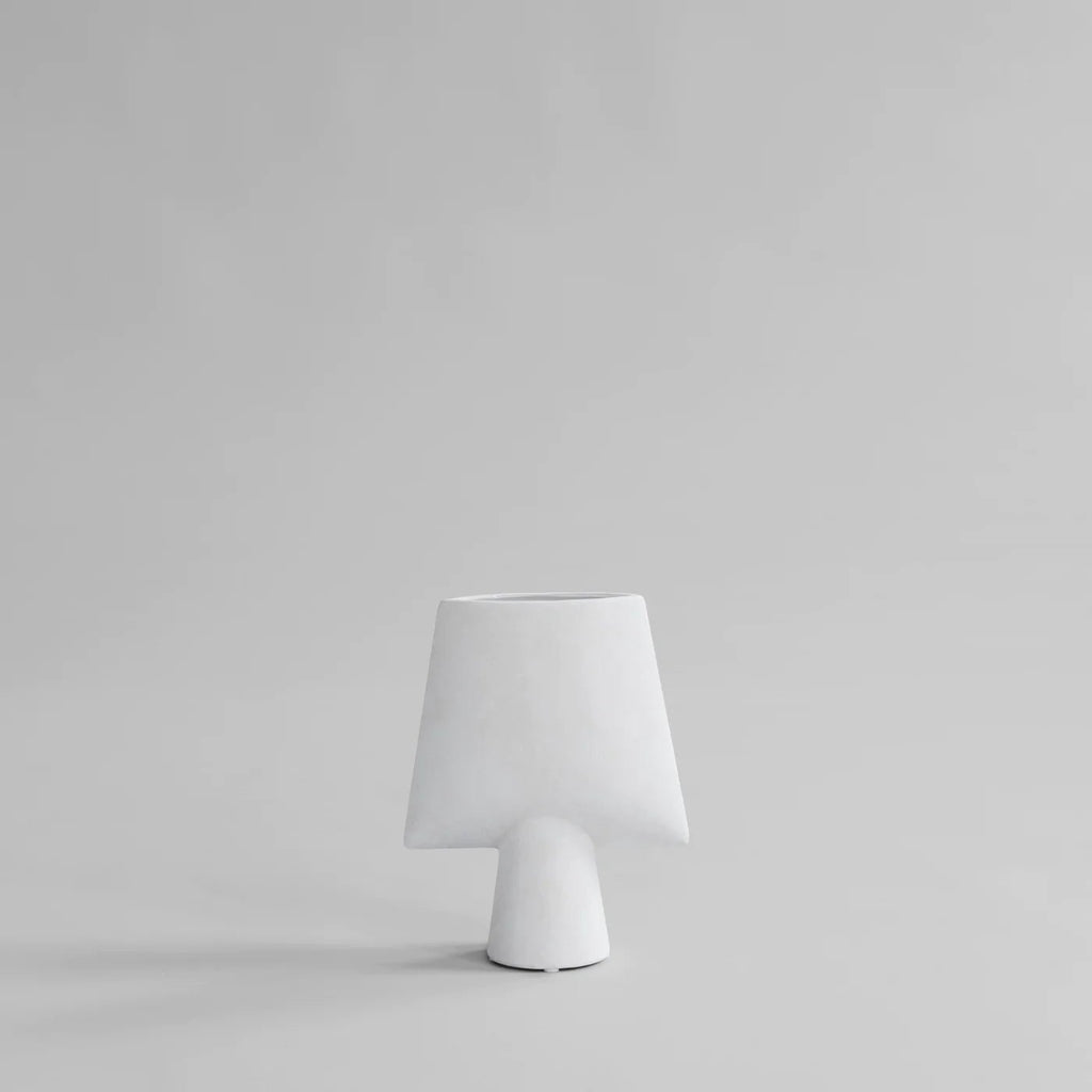 A small SPHERE VASE by 101 COPENHAGEN sitting on a grey surface.