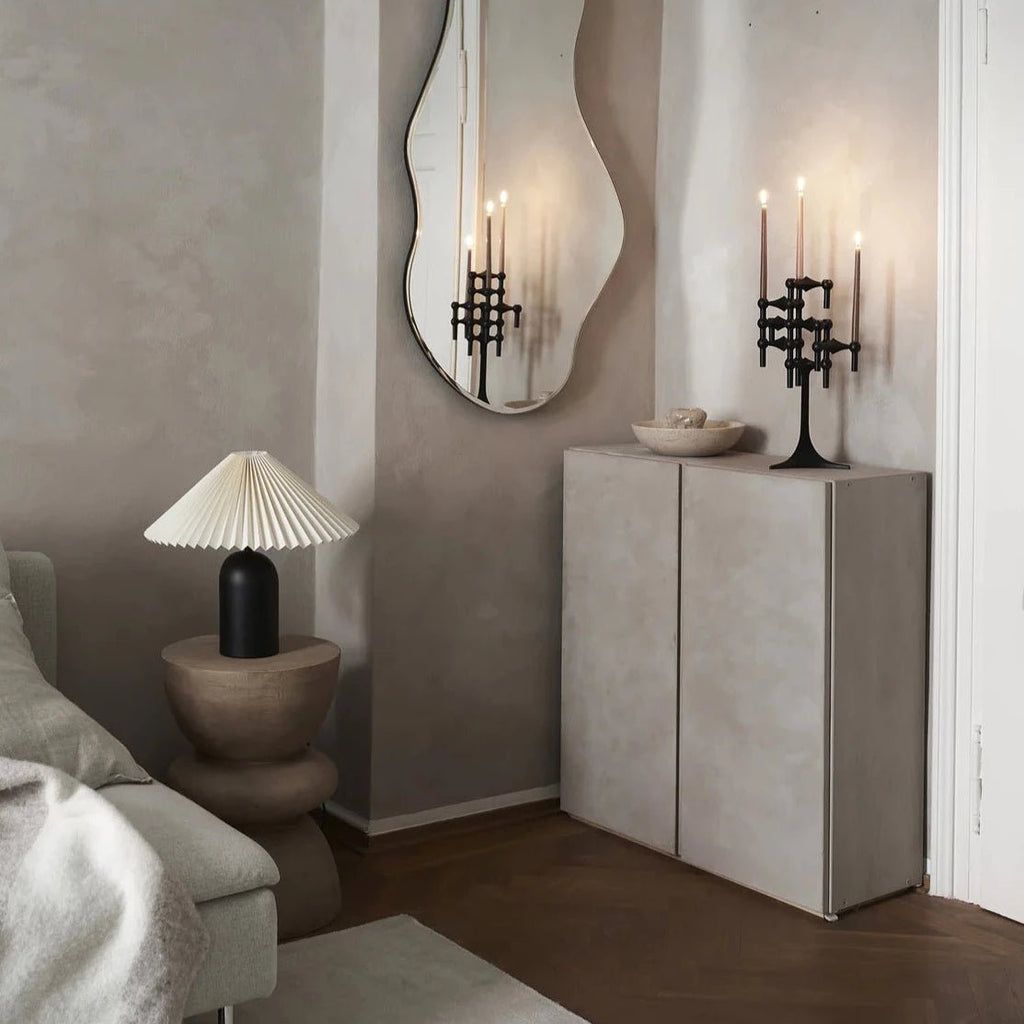 A Gestalt Haus room featuring a STOFF NAGEL mirror, couch, and lamp.