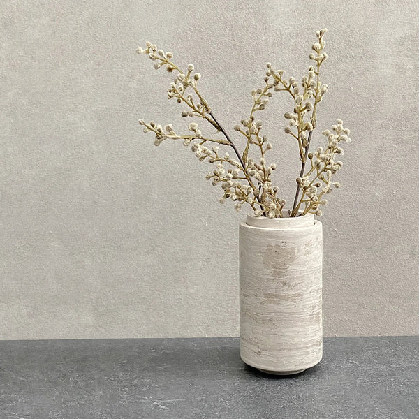 A STEM VASE from BRANDT COLLECTIVE with dried branches sitting on a Gestalt Haus table.
