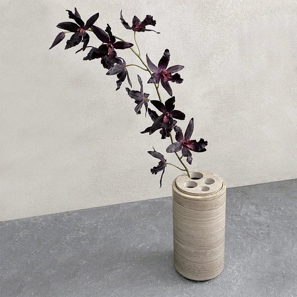 A BRANDT COLLECTIVE STEM VASE with flowers in it sitting on a concrete floor at Gestalt Haus.