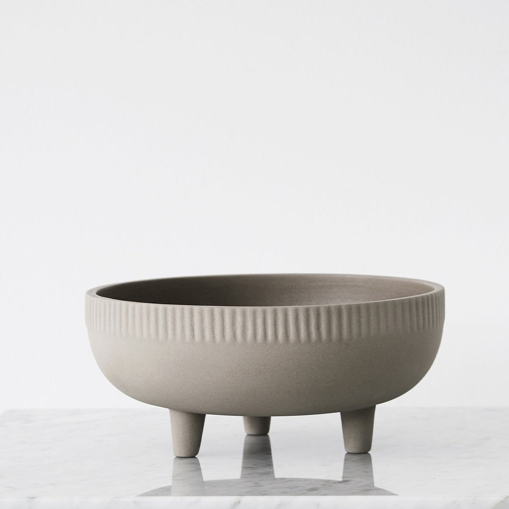 A small grey STUDIO BOWL on a marble table by KRISTINA DAM STUDIO with a Gestalt touch.