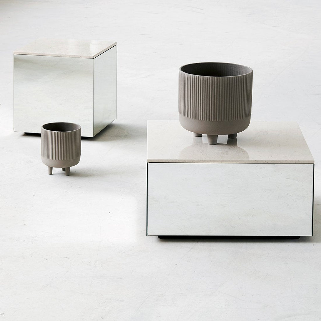 A small table with two STUDIO BOWL pots and a vase on it, by KRISTINA DAM STUDIO, exhibiting the essence of Gestalt design.