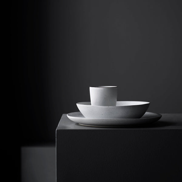 A Gestalt Haus cup and saucer sitting on top of a black box.