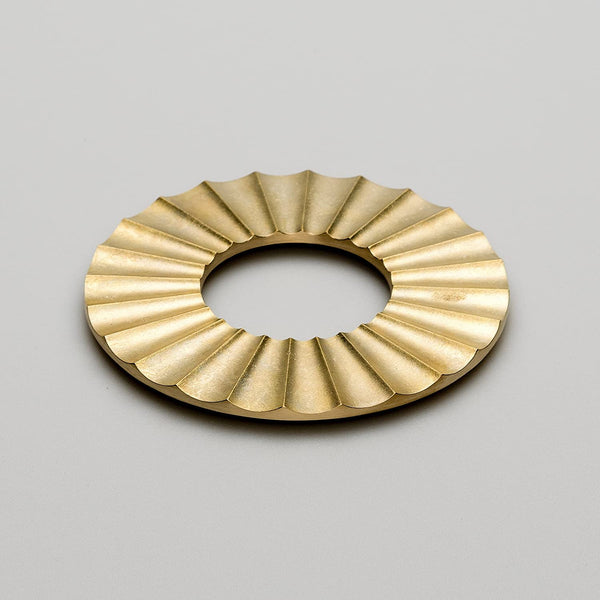 A FUTAGAMI SUN TRIVET on a white surface enhanced by the minimalist appeal of Gestalt Haus.