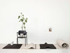 A chair and plant in a white room with Gestalt Haus aesthetic.