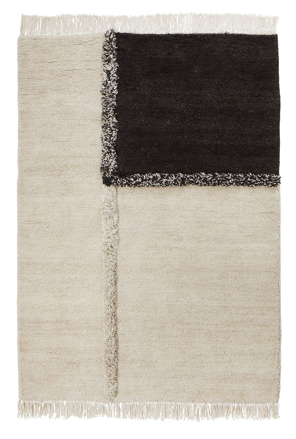 A black and white THE E-1027 RUG with fringes from SERA HELSINKI, inspired by the Gestalt Haus.