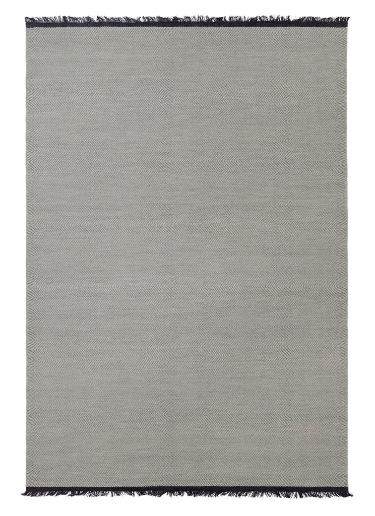 The Felicia Rug by Fabula Living is a grey rug with fringes on a white background, designed in the style of Gestalt Haus.
