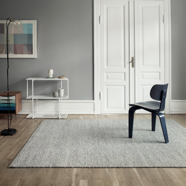 A grey Gestalt Haus with a chair and THE FENRIS RUG by FABULA LIVING.