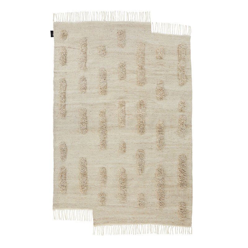 A THE LAINE RUG with fringes and fringes on a white background by SERA HELSINKI.