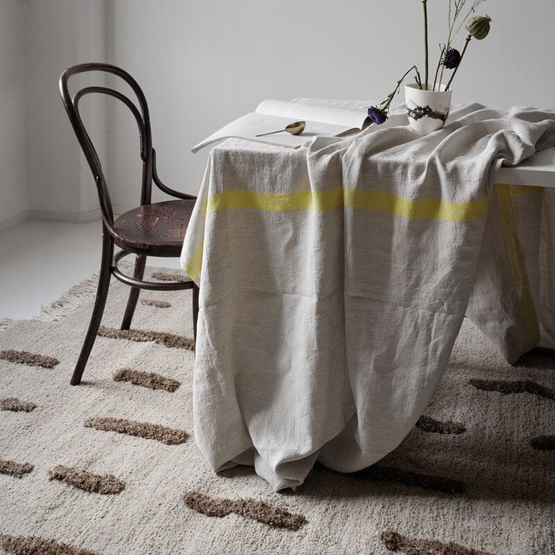THE LAINE RUG by SERA HELSINKI featuring a yellow stripe on a white table at Gestalt Haus.