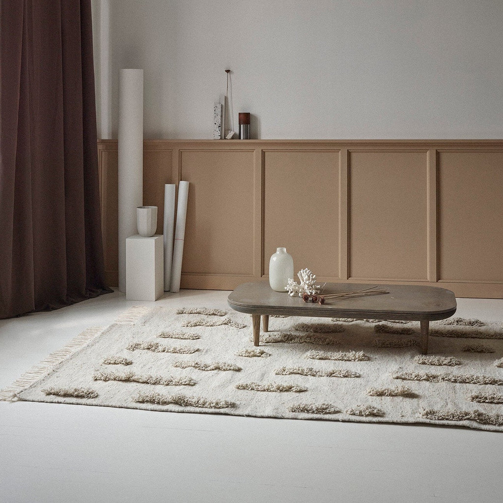 A room with white walls and a SERA HELSINKI THE LAINE RUG designed with Gestalt Haus aesthetics.