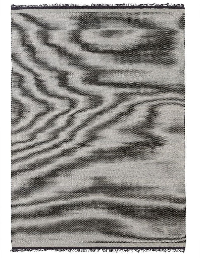 A grey NJORD rug with fringes made by Fabula Living.
