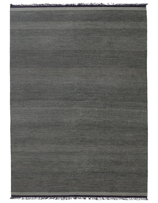 A grey Gestalt Haus rug with fringes on a white background by FABULA LIVING.