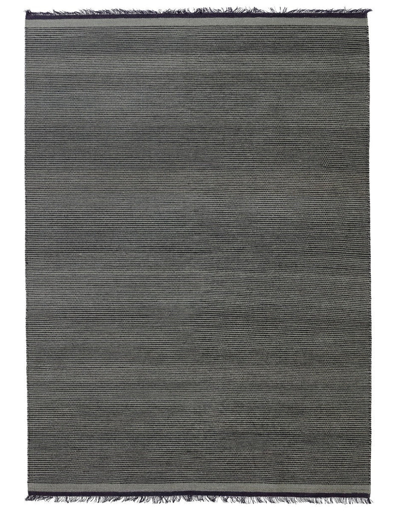 A grey Gestalt Haus rug with fringes on a white background by FABULA LIVING.