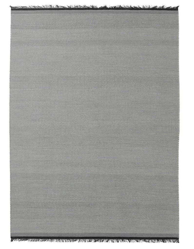 A grey NJORD rug with black fringes on a white background, by Fabula Living, inspired by the minimalist aesthetic of Gestalt design.