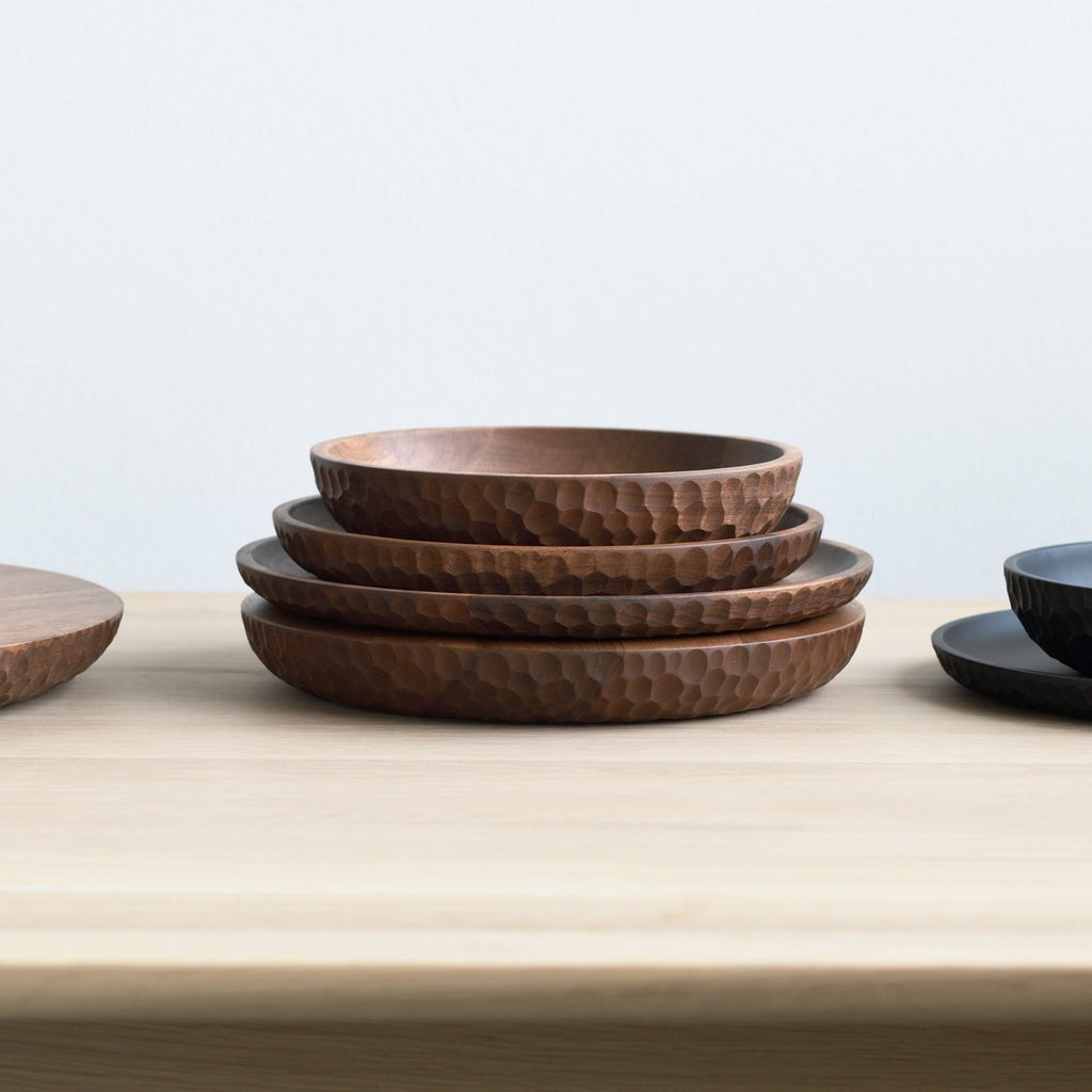 A set of Gestalt Haus touch bowls and plates on a wooden table.