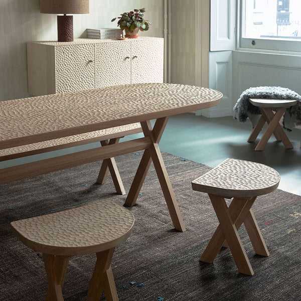 A wooden dining table and touch stools by ZANAT in a Gestalt Haus-inspired room.