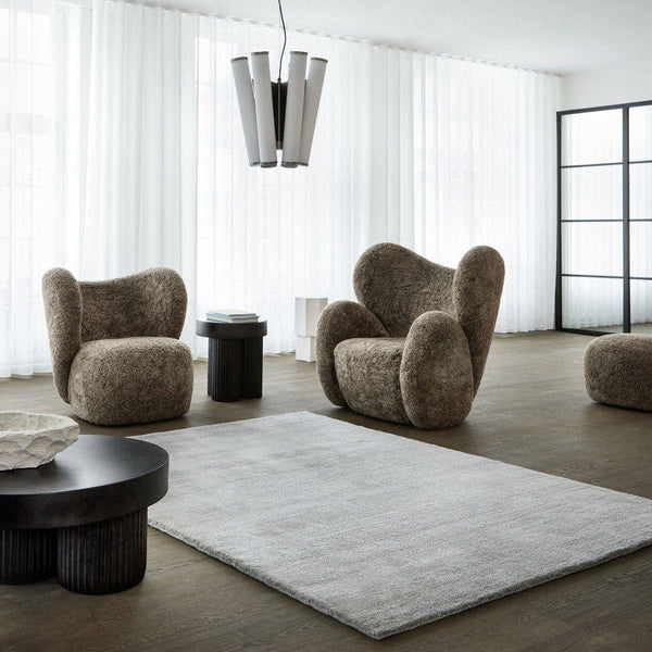 A living room with several chairs and THE VIDAR RUG by FABULA LIVING, featuring a Gestalt Haus design.