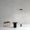 A Gestalt Haus featuring THE WISP LAMP from ANONY, accompanied by a table and stool.