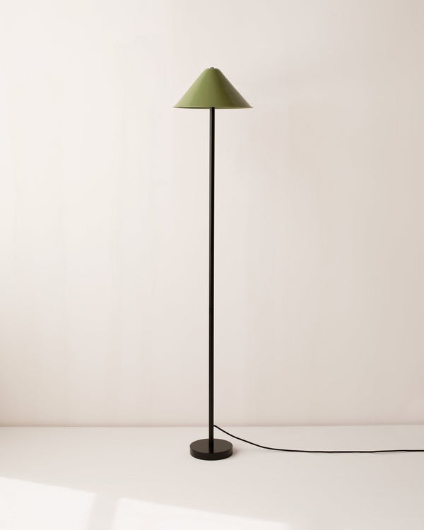 A TIPI floor lamp with a green shade and a black base, made by IN COMMON WITH in collaboration with Gestalt Haus.