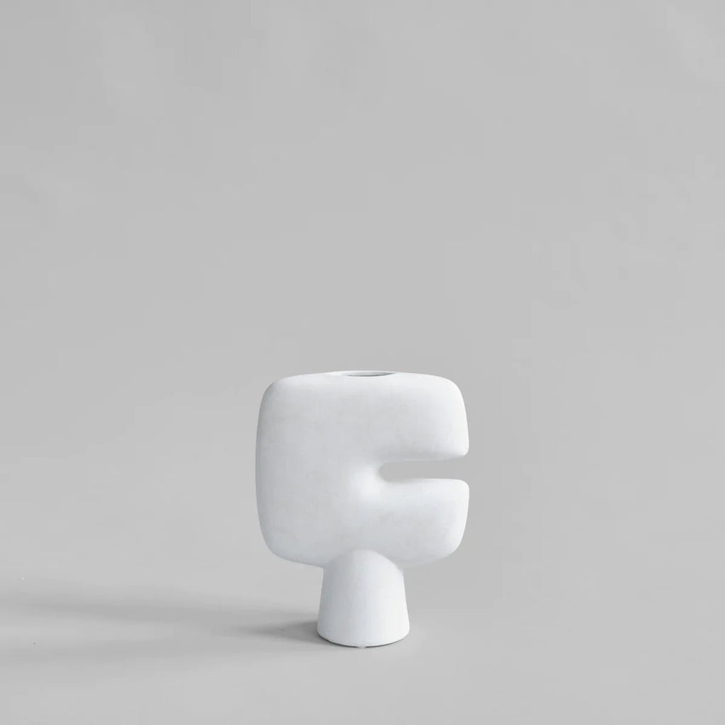 A TRIBAL VASE - MINI by 101 COPENHAGEN displayed on a Gestalt Haus-inspired grey surface.