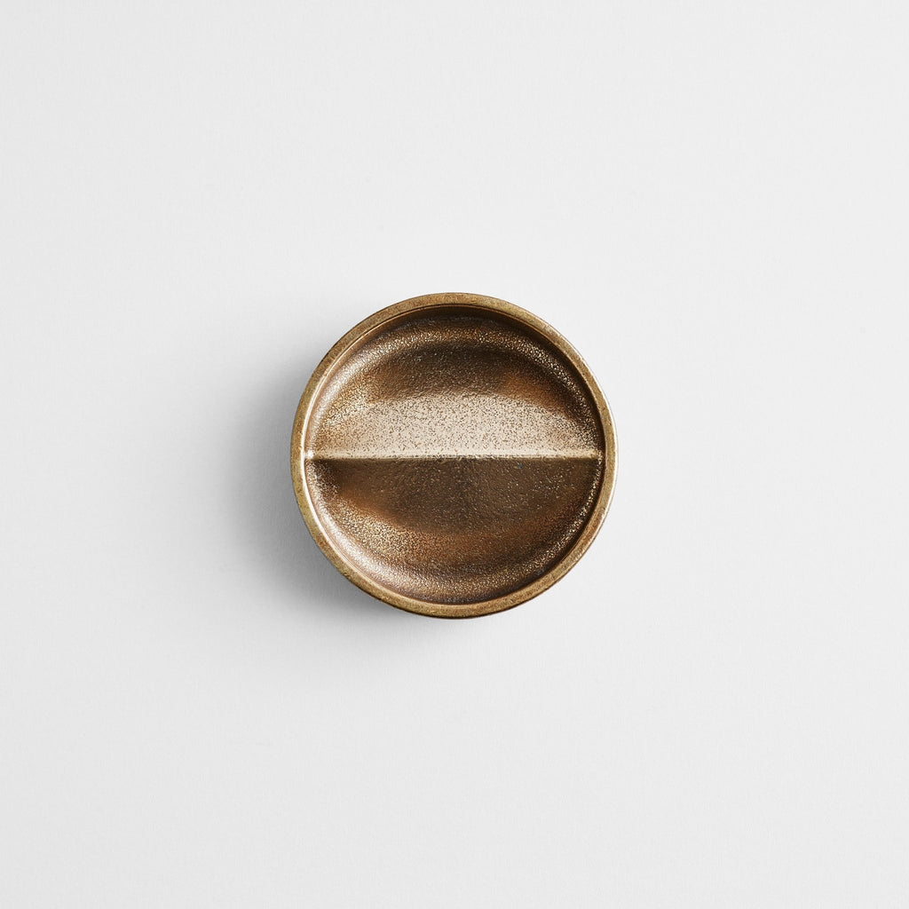 A brass knob on a white surface in the STUDIO HENRY WILSON.