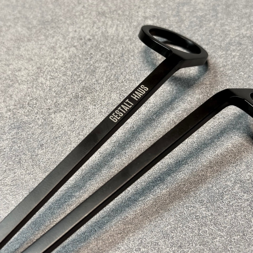 A pair of black WICK TRIMMER from Gestalt Haus on a grey surface.