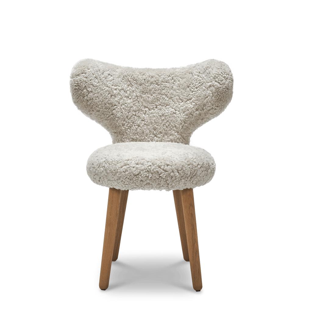 A Gestalt Haus WNG CHAIR with a white fur seat and wooden legs from MAZO.